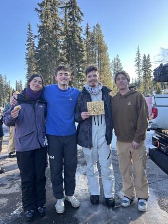 Four Elevation Oregon members at the mountain, one holding an Elevation Oregon card